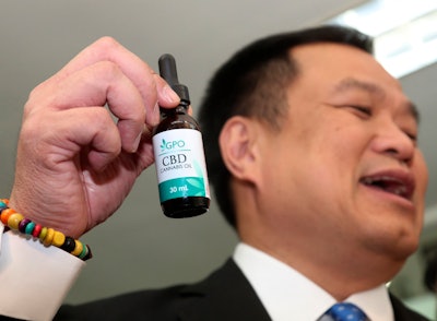 Thailand Public Health Minister Anutin Chanvirakul shows a bottle of extracted cannabis oil during a press conference in Bangkok, Aug. 7, 2019.