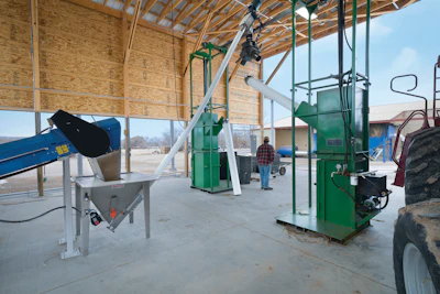 Biomass is discharged from the flexible screw conveyor into a wye diverter, which feeds two balers.