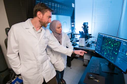 Jason Paris (left) and fourth-year graduate student Alaa Qrareya image calcium in cultured neural cells in Paris’ laboratory in 2019 at the School of Pharmacy, Oxford, Miss.