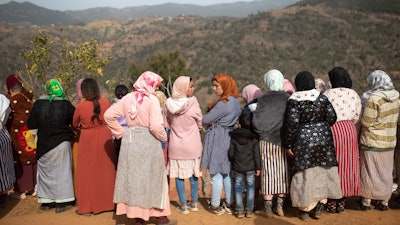 Women watch civil defense workers and local authorities attempt to rescue a boy who fell into a well, Ighran, Morocco, Feb. 4, 2022.