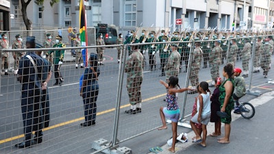 Children look on as President Cyril Ramaphosa's cavalcade is expected at the City Hall in Cape Town, Feb. 10, 2022.