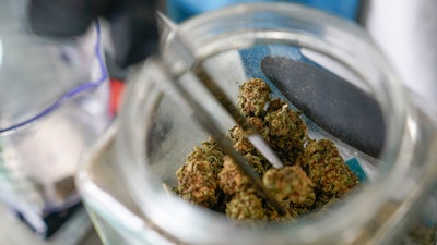 An employee at the Good Leaf Dispensary measures out marijuana for a customer on the reservation Mohawks call Akwesasne, March 14, 2022, St. Regis, N.Y.