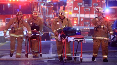 Los Angeles Fire Department firefighters push gurneys at the scene of a structure fire that injured multiple firefighters, May 16, 2020. The owner of a downtown Los Angeles building where an explosion injured 12 firefighters has been allowed to enter a judicial diversion program that allows him to avoid jail time. A court commissioner on Wednesday, March 30, 2022, granted Steve Sungho Lee's request to enter the two-year program.