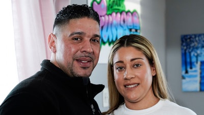 Eladio and Melissa Guzman pose for photographs, Monday, April 4, 2022, in Hicksville, N.Y. The couple, who endured the war on drugs, including jail time, are now eager to open a recreational marijuana dispensary in New York.