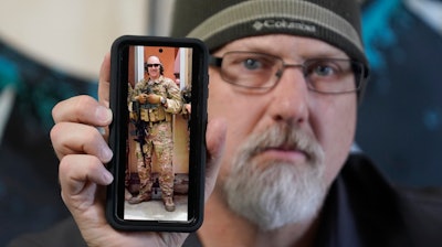 Matthew Butler, who spent 27 years in the Army, holds a 2014 photograph of himself during his last deployment in Kabul Afghanistan, on Wednesday, March 30, 2022, in Sandy, Utah.