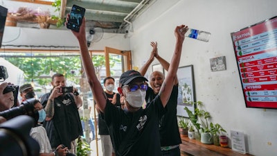 The first customer of the day, Rittipomng Bachkul celebrates after buying legal marijuana at the Highland Cafe in Bangkok, Thailand, Thursday, June 9, 2022. Measures to legalize cannabis became effective Thursday, paving the way for medical and personal use of all parts of cannabis plants, including flowers and seeds.