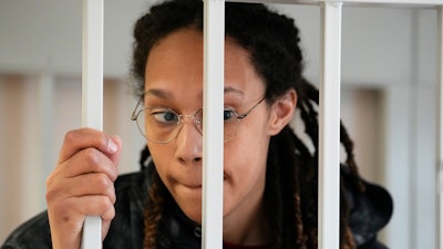 WNBA star and two-time Olympic gold medalist Brittney Griner stands in a cage at a court room prior to a hearing, in Khimki just outside Moscow, Russia, Tuesday, July 26, 2022. American basketball star Brittney Griner has returned to a Russian courtroom for her drawn-out trial on drug charges that could bring her 10 years in prison if convicted.