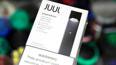 This Thursday, Dec. 20, 2018 file photo shows a Juul electronic cigarette starter kit at a smoke shop in New York. Altria reports its nearly $13 billion investment in troubled vaping company Juul is worth 95% less than it originally paid. The tobacco giant on Thursday, July 28, 2022, said its stake in the e-cigarette maker is now worth less than $500 million after U.S. regulators announced plans to ban Juul's vaping devices.