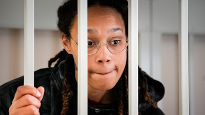 WNBA star and two-time Olympic gold medalist Brittney Griner speaks to her lawyers standing in a cage at a court room prior to a hearing, in Khimki just outside Moscow, Russia, Tuesday, July 26, 2022. American basketball star Brittney Griner returns Tuesday to a Russian courtroom for her drawn-out trial on drug charges that could bring her 10 years in prison of convicted.