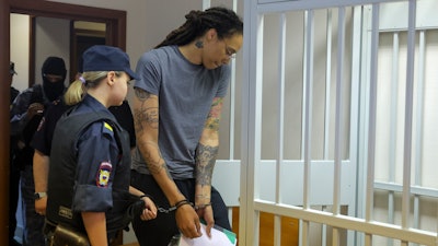 WNBA star and two-time Olympic gold medalist Brittney Griner, right, enters a cage in a courtroom prior to a hearing in Khimki just outside Moscow, Russia, Thursday, Aug. 4, 2022. Closing arguments in Brittney Griner's cannabis possession case are set for Thursday, nearly six months after the American basketball star was arrested at a Moscow airport in a case that reached the highest levels of US-Russia diplomacy.