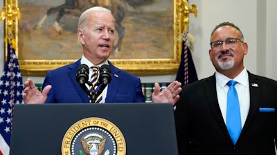 President Joe Biden speaks about student loan debt forgiveness in the Roosevelt Room of the White House, Aug. 24, 2022, in Washington. Education Secretary Miguel Cardona listens at right. Many have cheered President Joe Biden's proposal to provide student loan forgiveness to millions of Americans as a significant step toward addressing the nation's racial wealth gap and other inequities facing borrowers of color.
