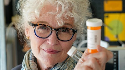 Mary Beth Orr holds medicine bottles used to give her doses of psilocybin, the compound in psychedelic mushrooms, as part of a study to try and help heavy drinkers cut back or quit entirely.