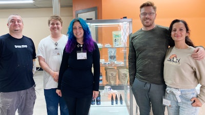 Ana and Josh MacDuff, right, and their employees pose inside their new Mountain Girl Cannabis store, Thursday, Sept. 29, 2022, in Rutland, Vt.