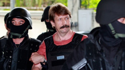 Suspected Russian arms smuggler Viktor Bout, center, is led by armed Thai police commandos as he arrives at the criminal court in Bangkok, Thailand in Oct. 5, 2010.