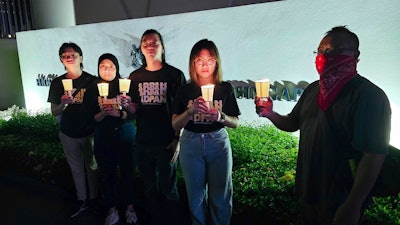 In this image taken and provided by Anti-Death Penalty Asia Network, members of Anti-Death Penalty Asia Network (ADPAN) hold candle outside Singapore Embassy in Kuala Lumpur, Malaysia Wednesday, April 26, 2023.
