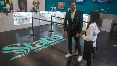 Brandon Bianco, operations manager for Statis Cannabis Company dispensary, left, confers with Alex Silecchia, right, a store budtender, also known as a sales associate, tender, Friday, Sept. 29, 2023, in New York.