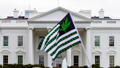 A demonstrator waves a flag with marijuana leaves depicted on it during a protest calling for the legalization of marijuana, outside of the White House on April 2, 2016, in Washington.