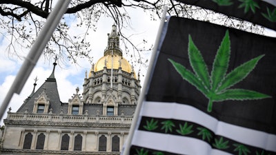Flags with a marijuana leaf wave outside the Connecticut State Capitol building, April 20, 2021, in Hartford, Conn.