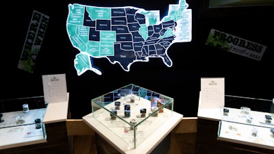 A map of cannabis legalization in the U.S. glows behind flower displays at the Empire Cannabis Club, Nov. 16, 2022, in New York. An advisory board approved on Tuesday, Feb. 13, 2024 a list of proposed rules and regulations that would govern the recreational use of cannabis in the U.S. Virgin Islands.