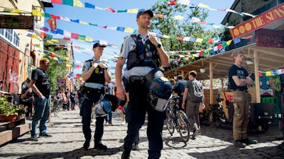 Police patrol Pusher Street in at Christiania, Copenhagen, Friday, May 25, 2018, after the street reopened after having been closed for three days.