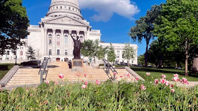 In this image provided by Shelby Ellison, tulips bloom in a flower bed in front to the Wisconsin Capitol, Thursday, May 16, 2024, in Madison, Wis.