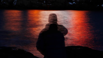 In this photo made with a long exposure, a man is silhouetted against lights reflected in the waters off Cape Neddick in Maine on Dec. 11, 2017. Federal health advisers are considering the first request to approve the mind-altering club drug MDMA as a treatment for PTSD. The advisers to the Food and Drug Administration are scheduled to vote on the drug's safety and effectiveness Tuesday, June 4, 2024, potentially setting the stage for federal approval later this year.