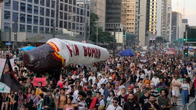 Demonstrators carry a giant inflatable joint during a march demanding the legalization of marijuana in Sao Paulo, Sunday, June 16, 2024.