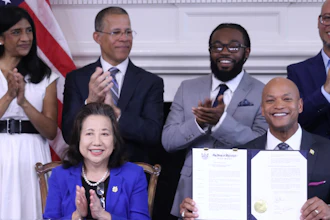 Maryland Gov. Wes Moore, bottom right, holds up an executive order he signed to issue more than 175,000 pardons for marijuana convictions, Monday, June 17, 2024, in Annapolis, Md.