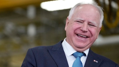 Minnesota Gov. Tim Walz, right, laughs as he stands with Fridley, Minn., Mayor Scott Lund during a visit to the Cummins Power Generation Facility in Fridley, Minn., Monday, April 3, 2023.