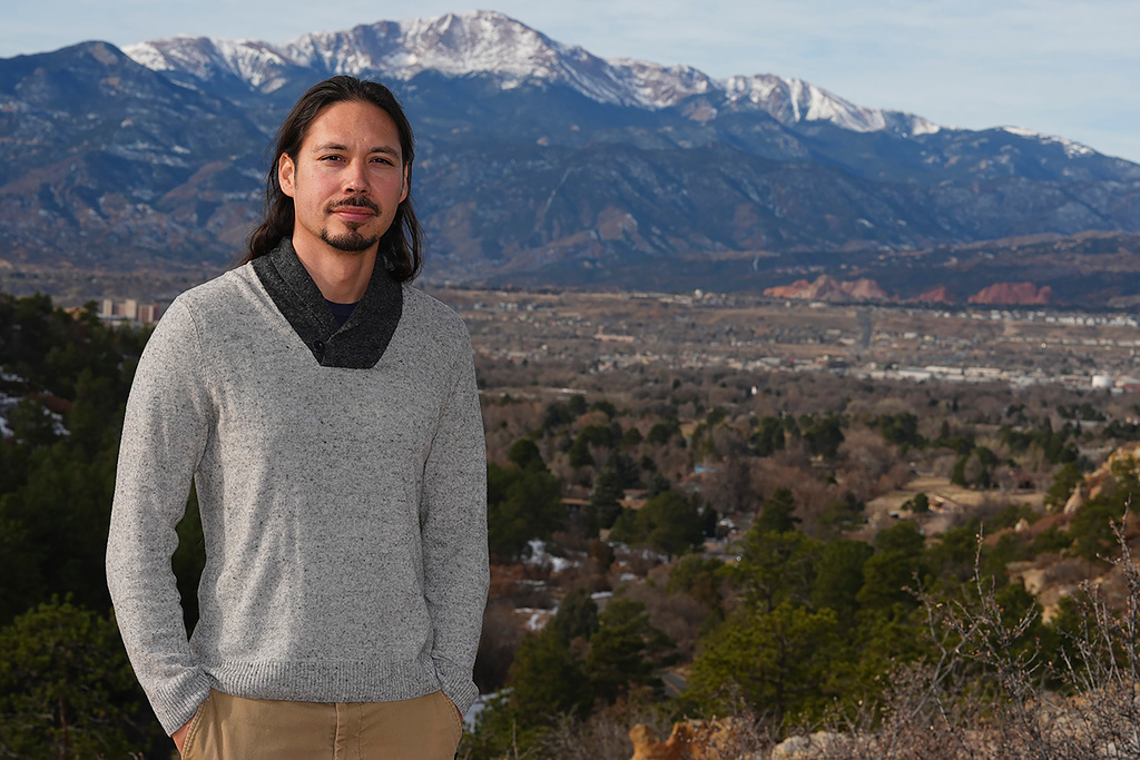 Lane Belone poses with Pikes Peak in the background on an overlook in Palmer Park, Thursday, Dec. 19, 2024, in Colorado Springs, Colo.
