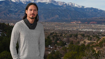 Lane Belone poses with Pikes Peak in the background on an overlook in Palmer Park, Thursday, Dec. 19, 2024, in Colorado Springs, Colo.