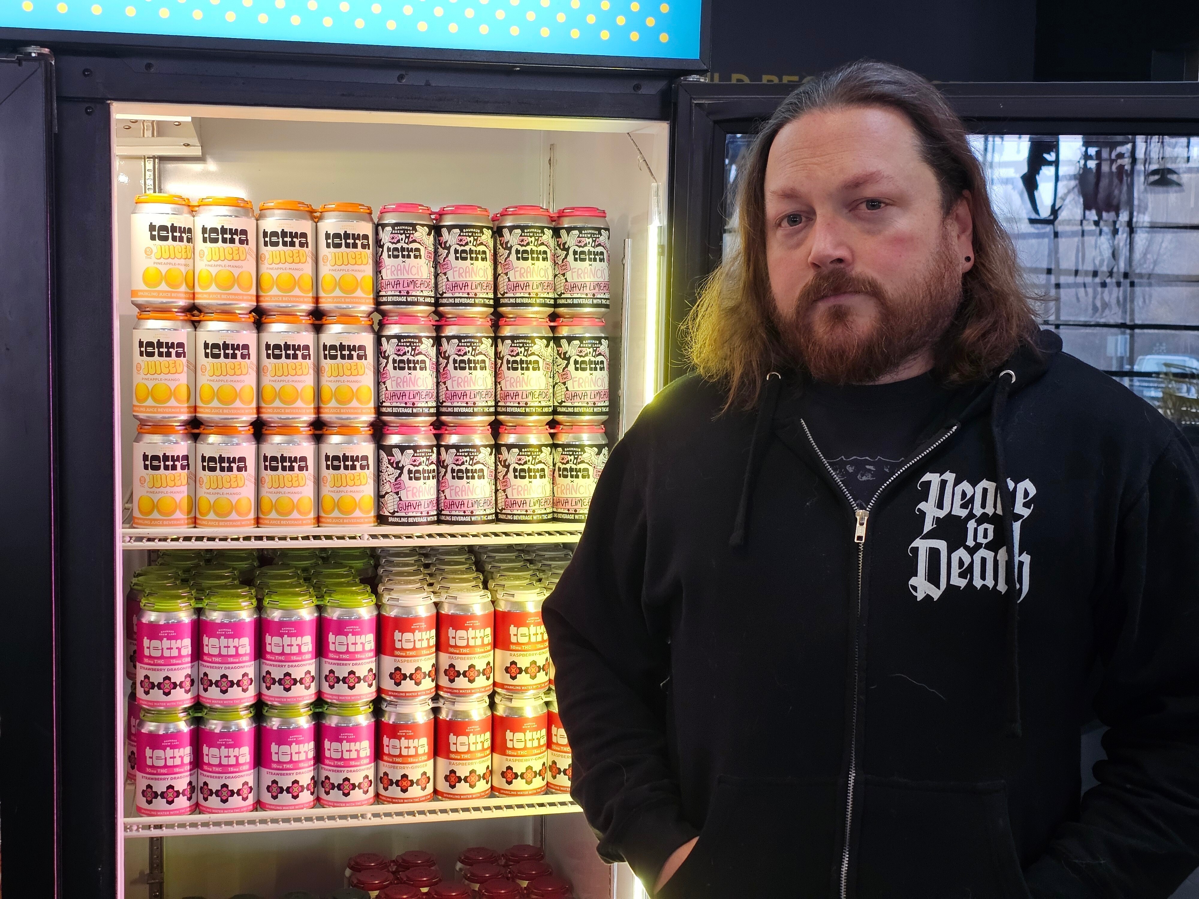 Drew Hurst, president and chief operating officer of Bauhaus Brew Labs in Minneapolis, stands outside a cooler for cans of seltzer containing THC, the active ingredient in marijuana, in his brewery's taproom on Thursday, Nov. 20, 2025.