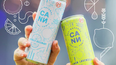 Two hands holding CANN natural tonic cans in blue grapefruit rosemary and yellow lemon lavender flavors at an outdoor event