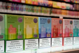 Row of colorful BC5000 vape product boxes on retail shelf with nicotine warning labels