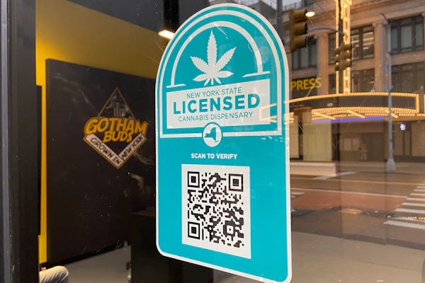 New York State licensed cannabis dispensary verification badge with QR code on storefront