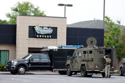 Law enforcement vehicles parked outside Cornubia Outlet storefront with armed personnel present