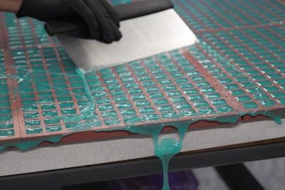 Technician in black gloves inspecting green PCB circuit board during quality control process