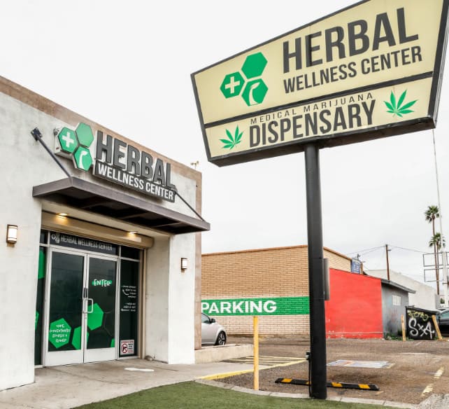 Herbal Wellness Center medical marijuana dispensary storefront with green signage and parking area