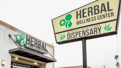 Herbal Wellness Center medical marijuana dispensary storefront with green signage and parking area
