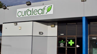 Curaleaf dispensary storefront with green logo, blue pillar, and dark entrance doors at address 5400