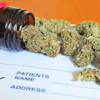 Medical cannabis buds spilling from prescription bottle onto Rx prescription pad against orange background