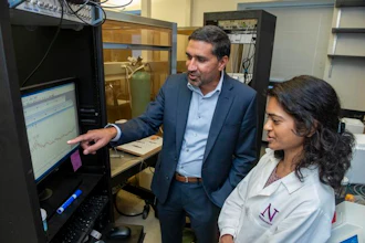 Man and woman examine data on computer monitor in laboratory with scientific equipment