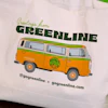 GO Greenline vintage bus tote bag with orange and green retro van graphic and contact information