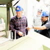 Industrial workers in hard hats discussing equipment at a manufacturing facility